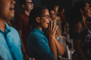 woman praying while closing her eyes