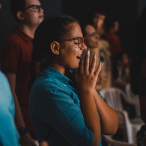 woman praying while closing her eyes