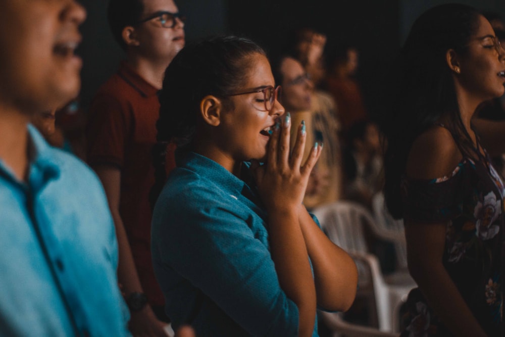 woman praying while closing her eyes