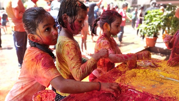 Children joyfully playing with colorful paints and textures.