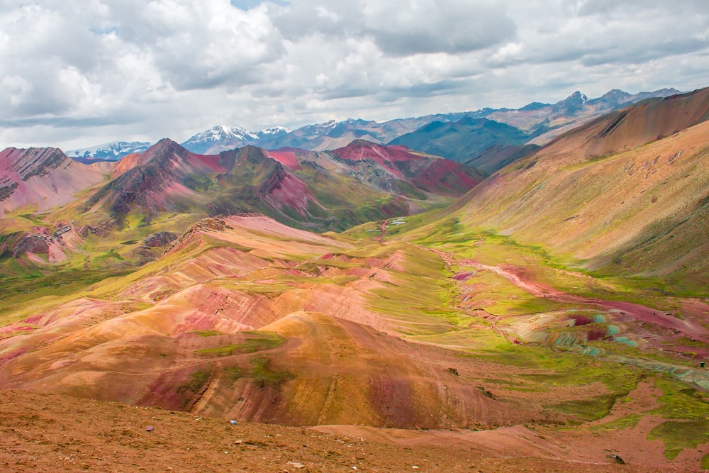 brown and green hills under white clouds