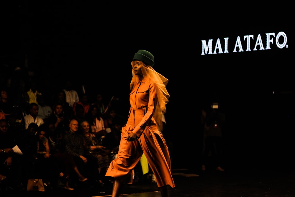 woman in brown overalls walking in front of people