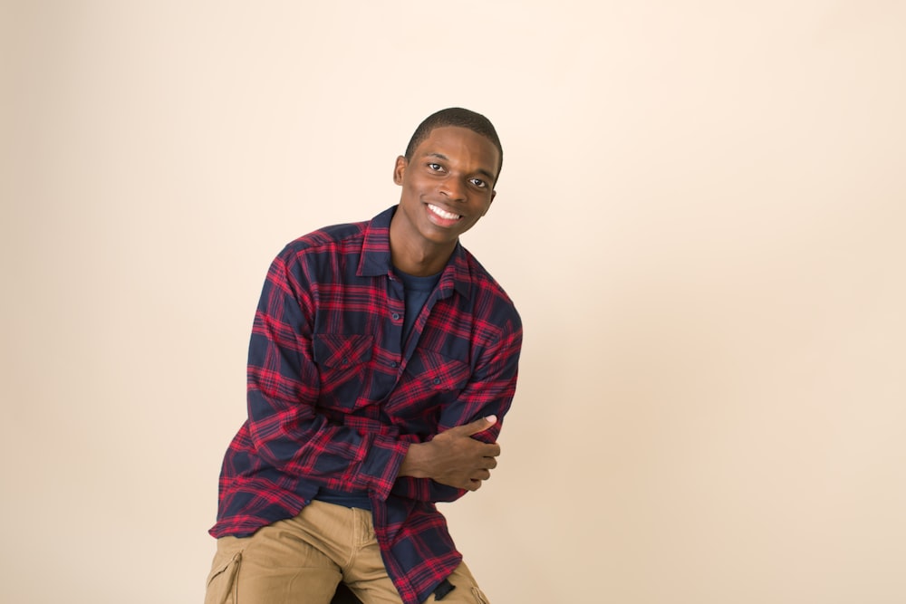 man leaning on wall while smiling