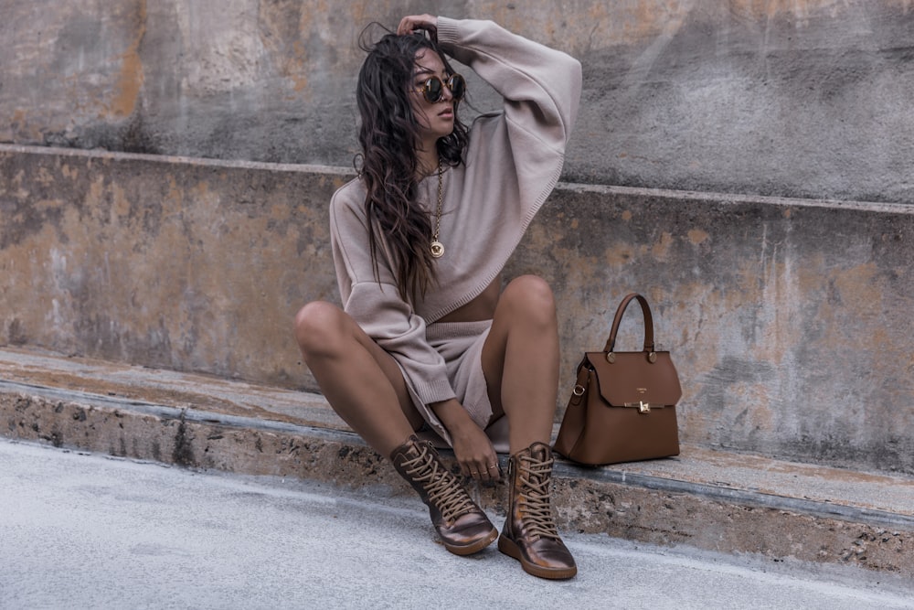 woman sitting on pathway during daytime