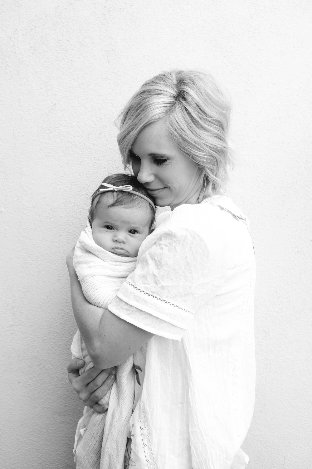 아기를 안고 있는 여자의 회색조 사진