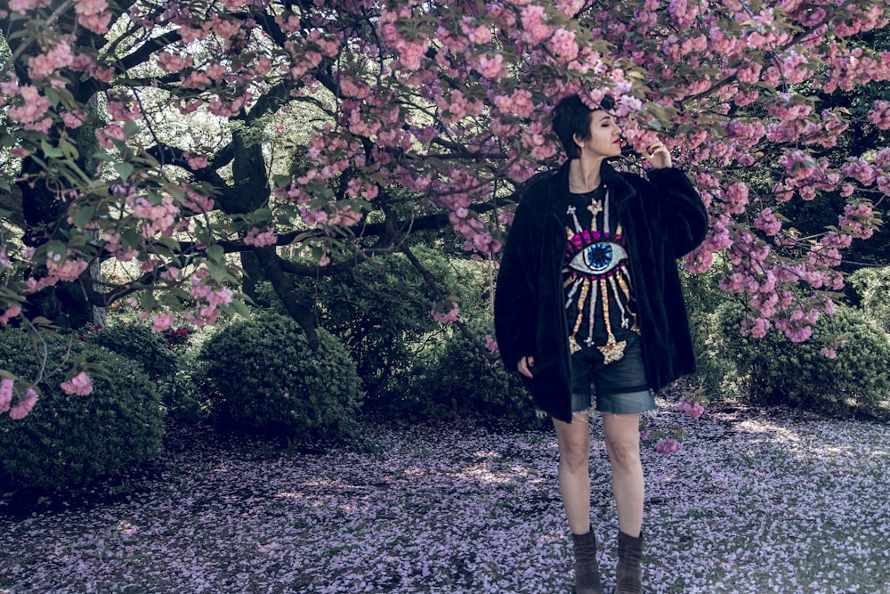 woman standing under cherry blossom tree