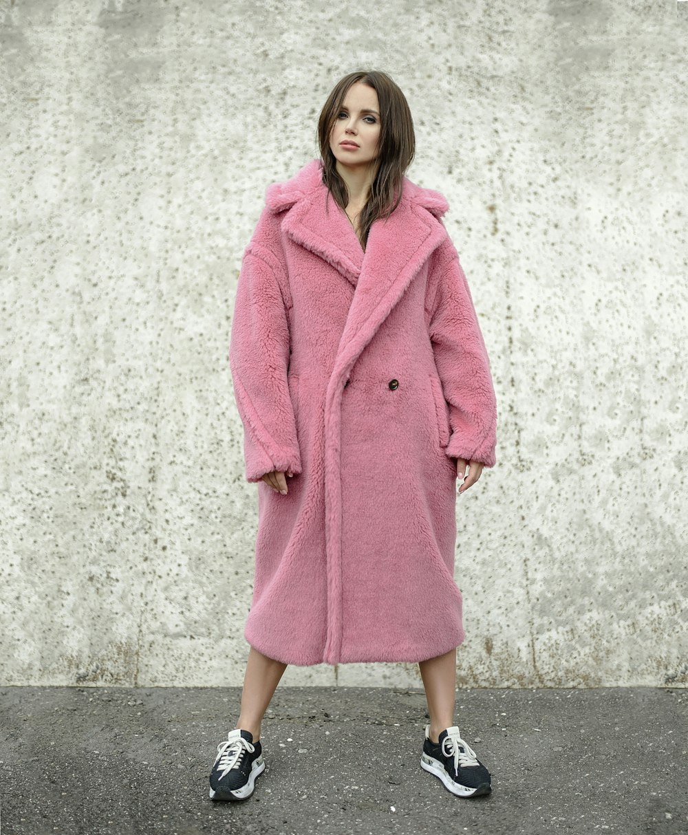 femme debout tout en portant un manteau rose
