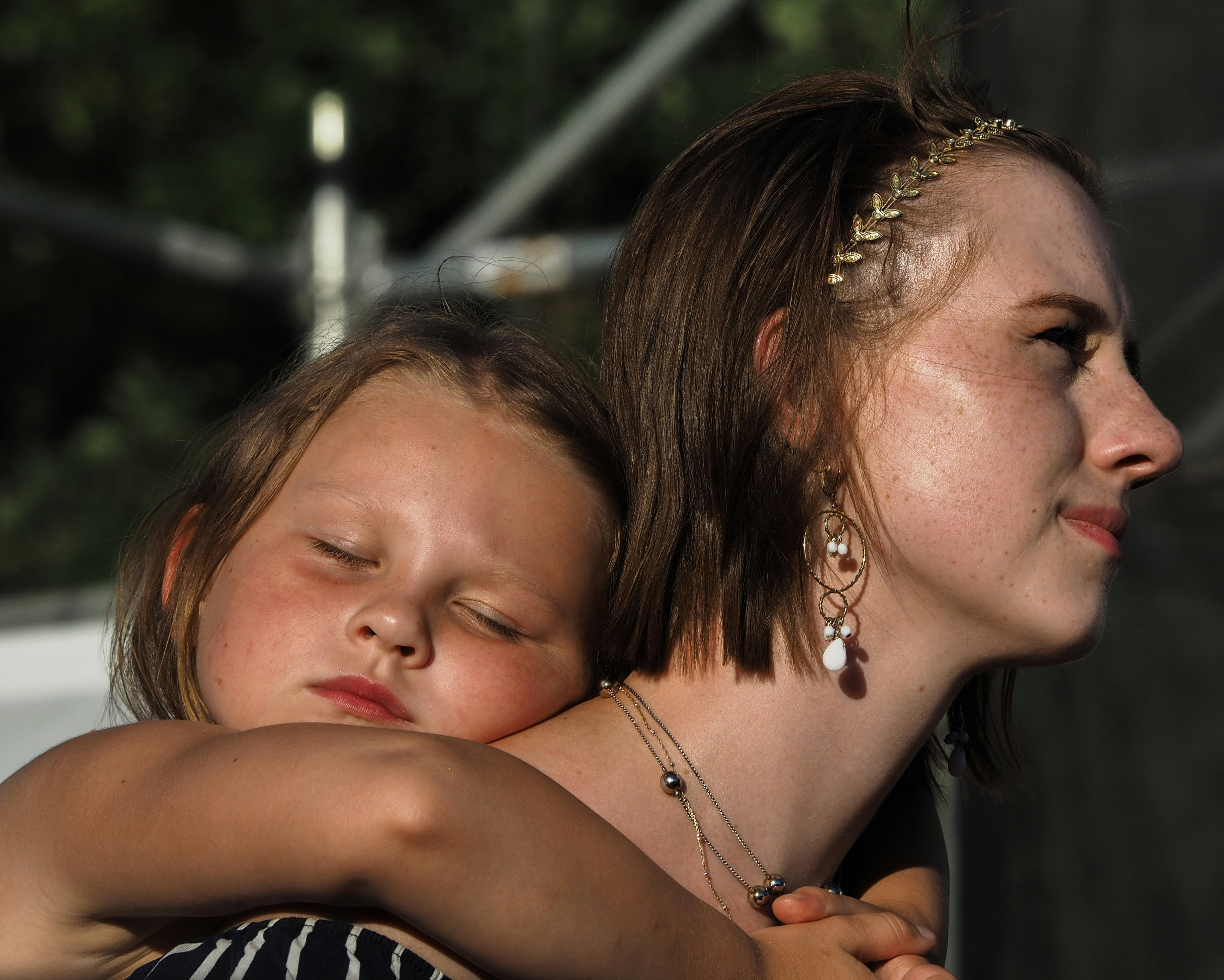 selective focus photography of woman carrying girl on back