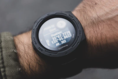 Garmin GPS watch displaying a detailed map on its screen with a sporty wrist in view