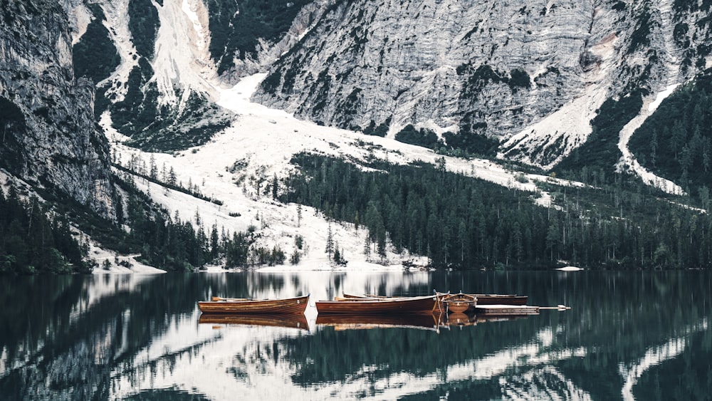 a boat sitting on top of a lake surrounded by mountains