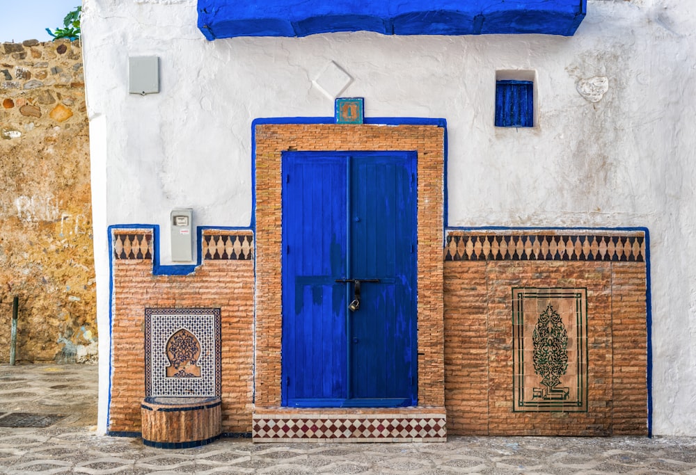 Un bâtiment bleu et blanc avec une porte bleue