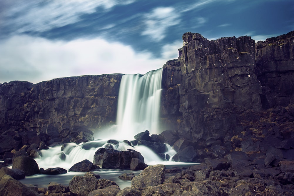 waterfalls under white and blue sky