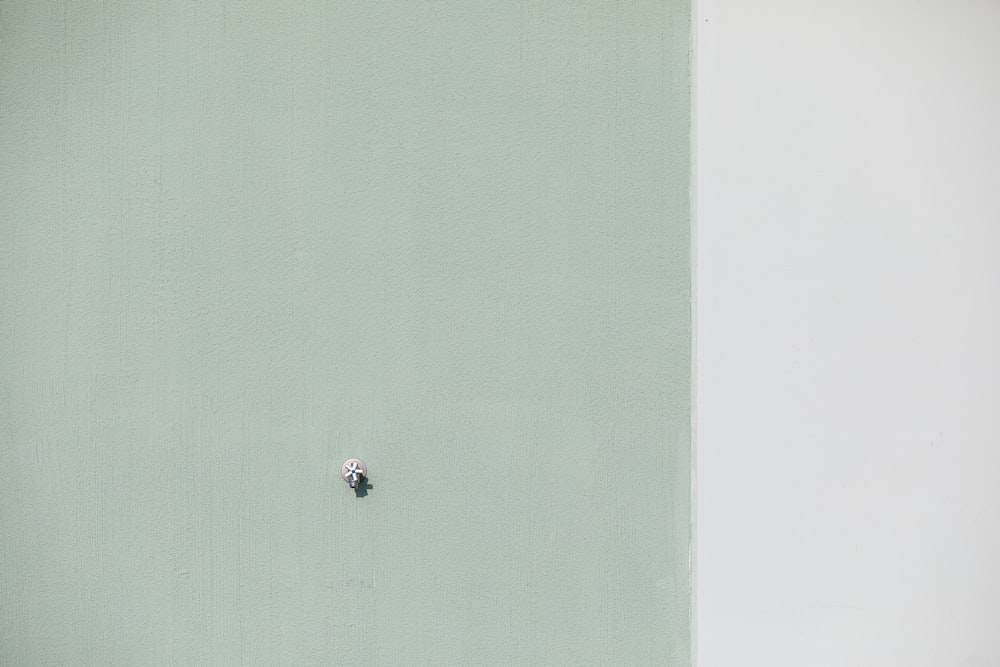 Un inodoro blanco sentado junto a una pared verde