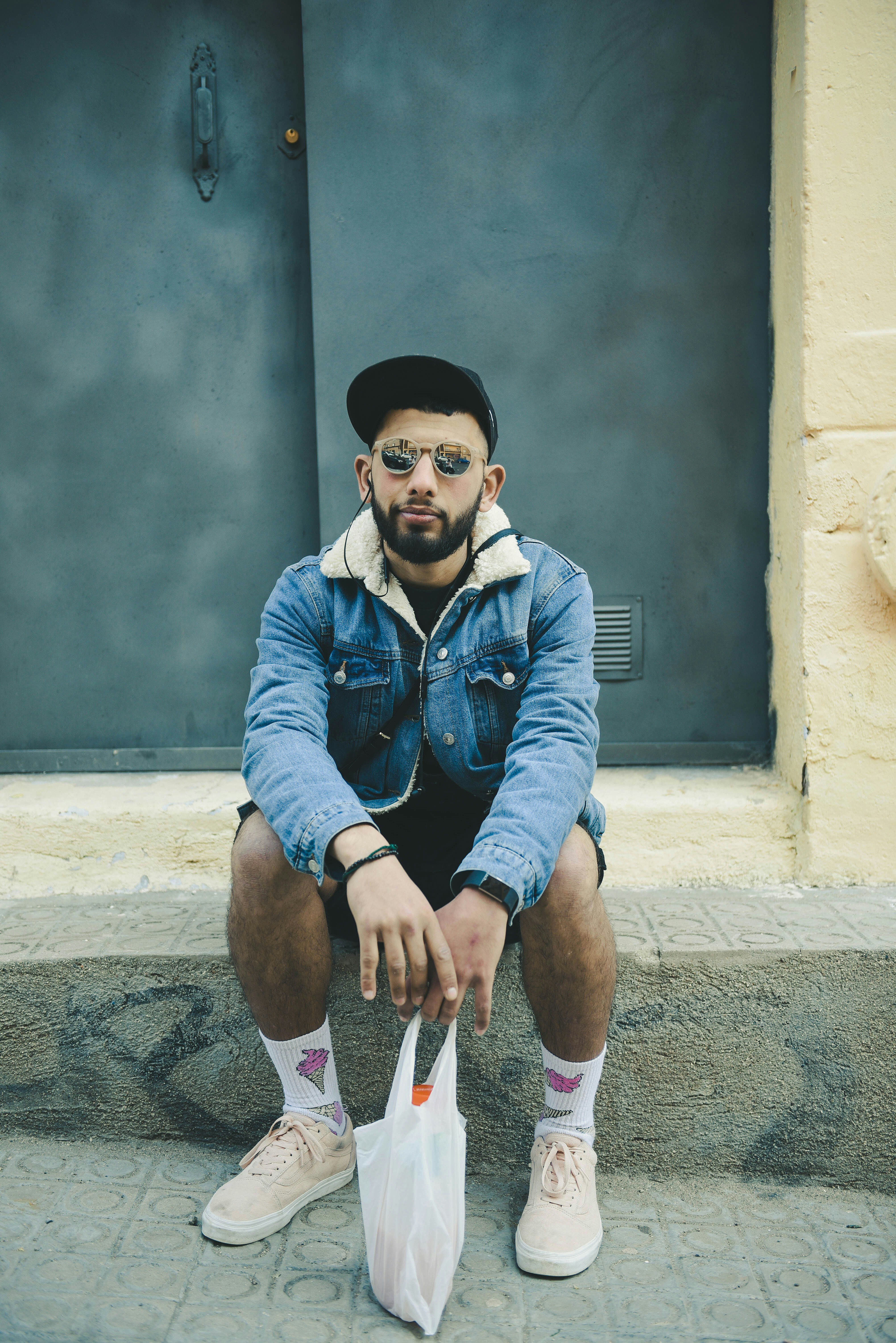 man sitting on sidewalk during daytime