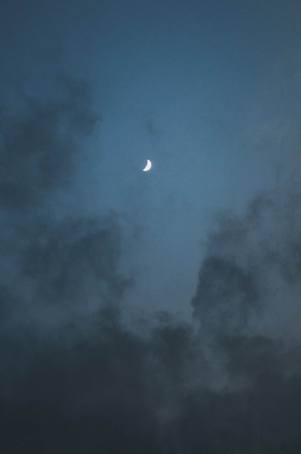the moon is seen through the dark clouds