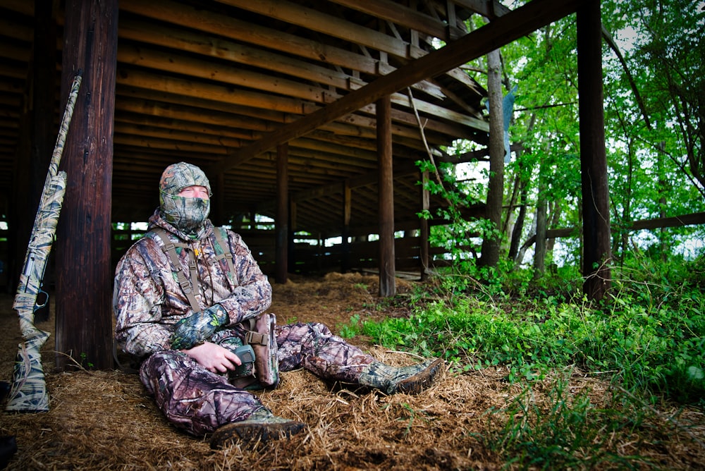 solder with rifle sitting under brown wooden roof