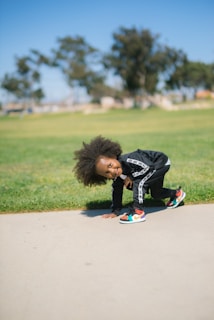 Smiling child wearing colorful Pasofirme shoes playing in a sunny park.