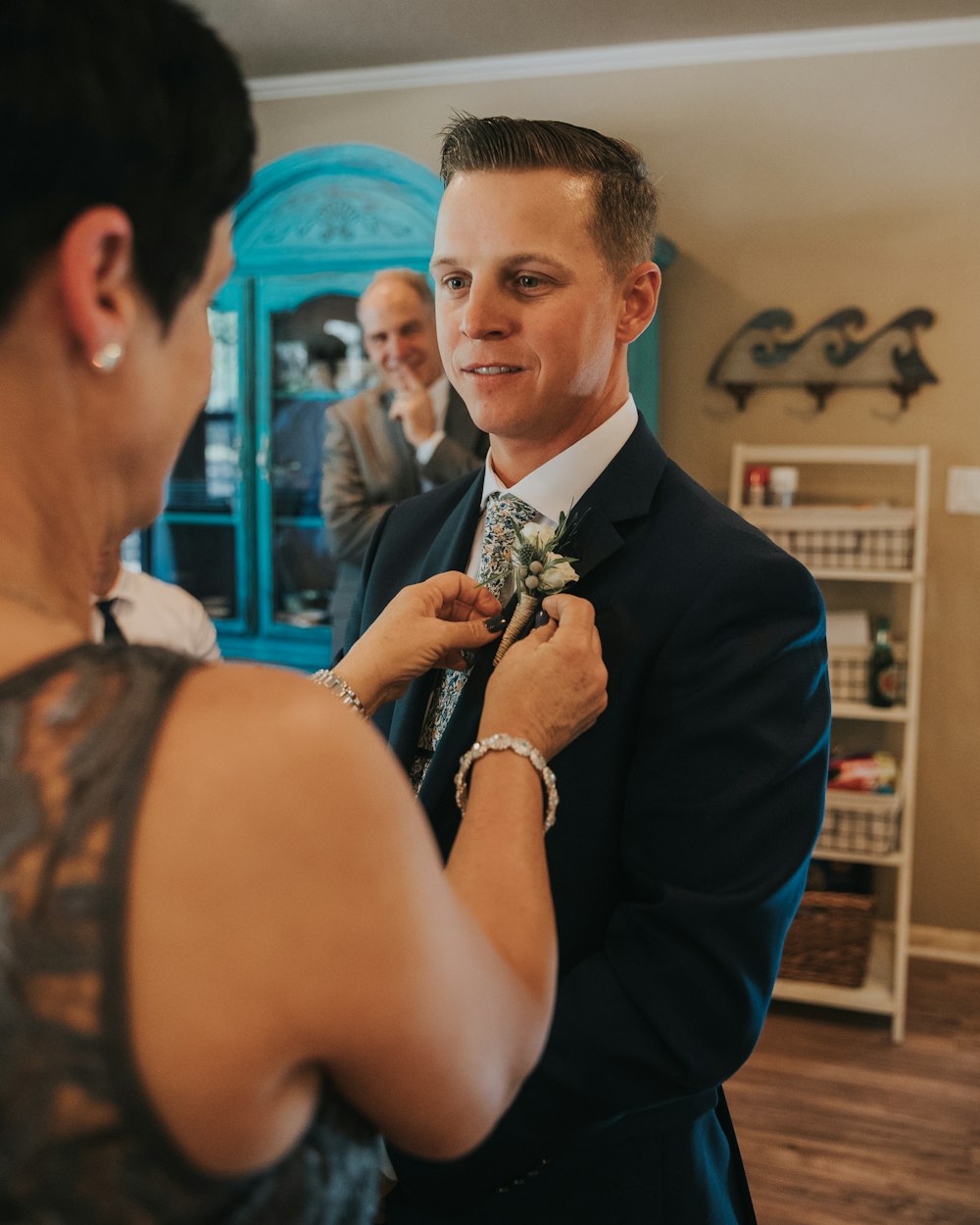 woman fixing flower on men's blazer