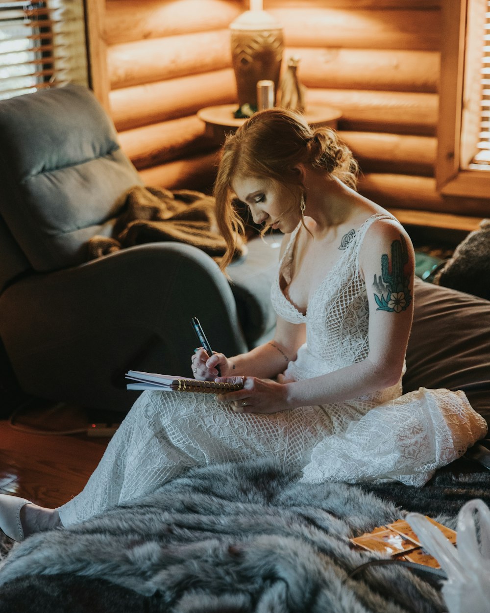 bride writing on notebook while sitting on bed