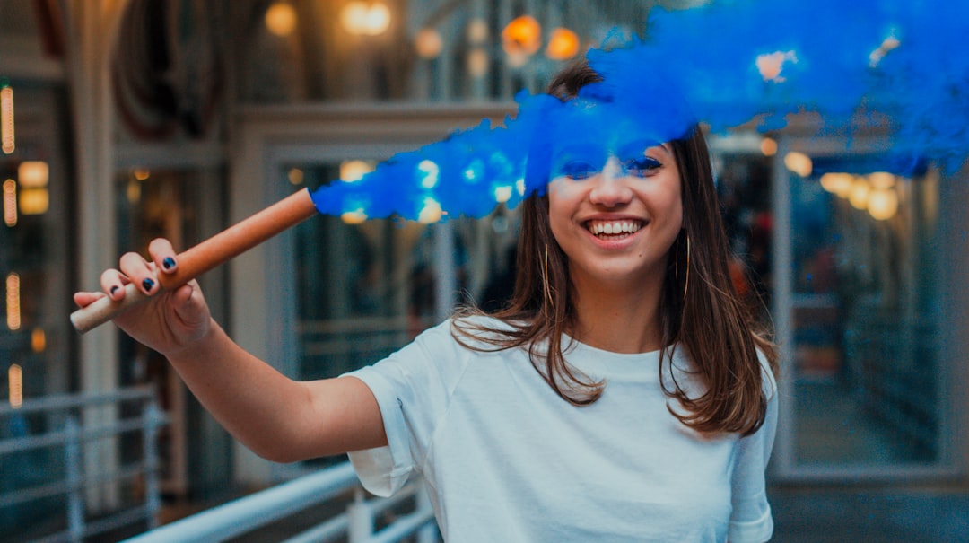 woman holding stick with blue smoke