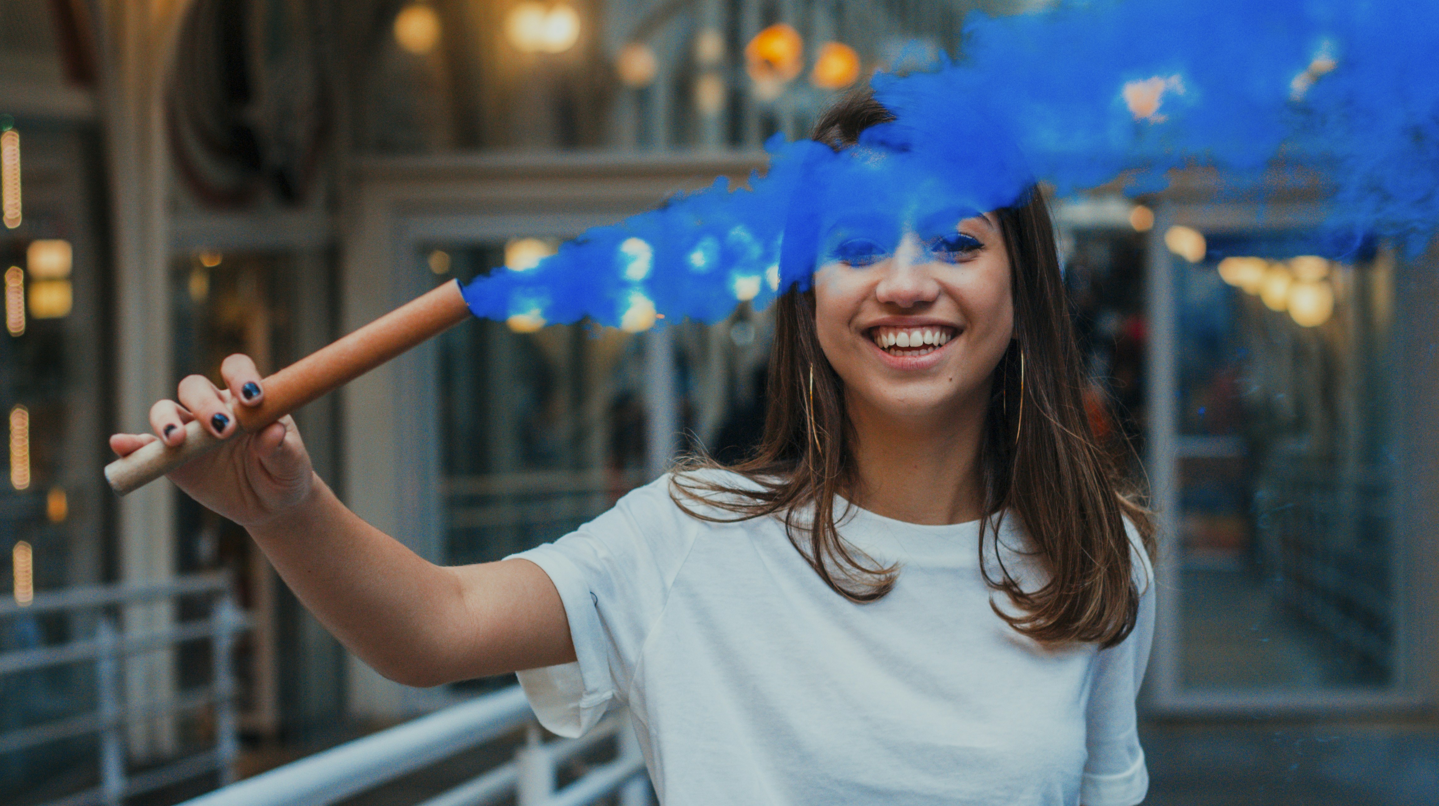 woman holding stick with blue smoke