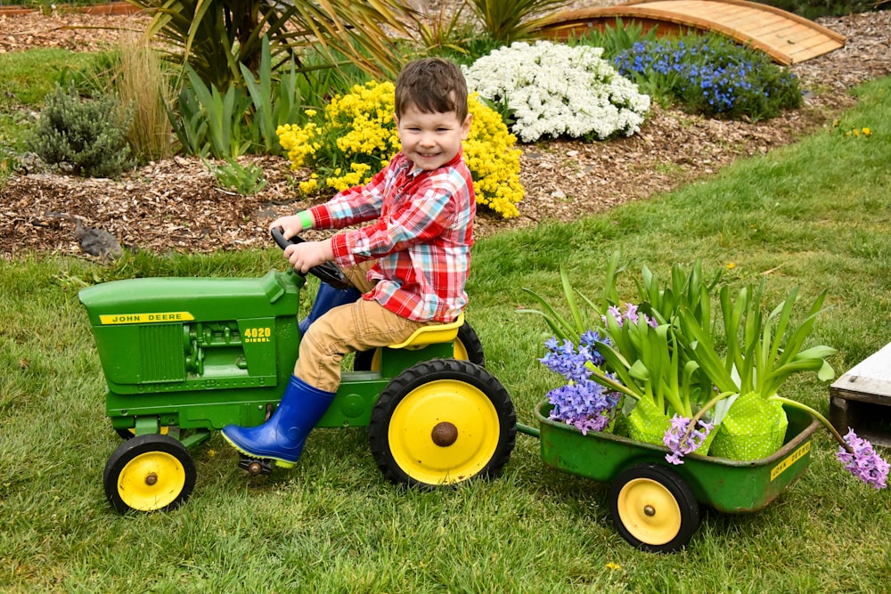 boy riding riding mower toy