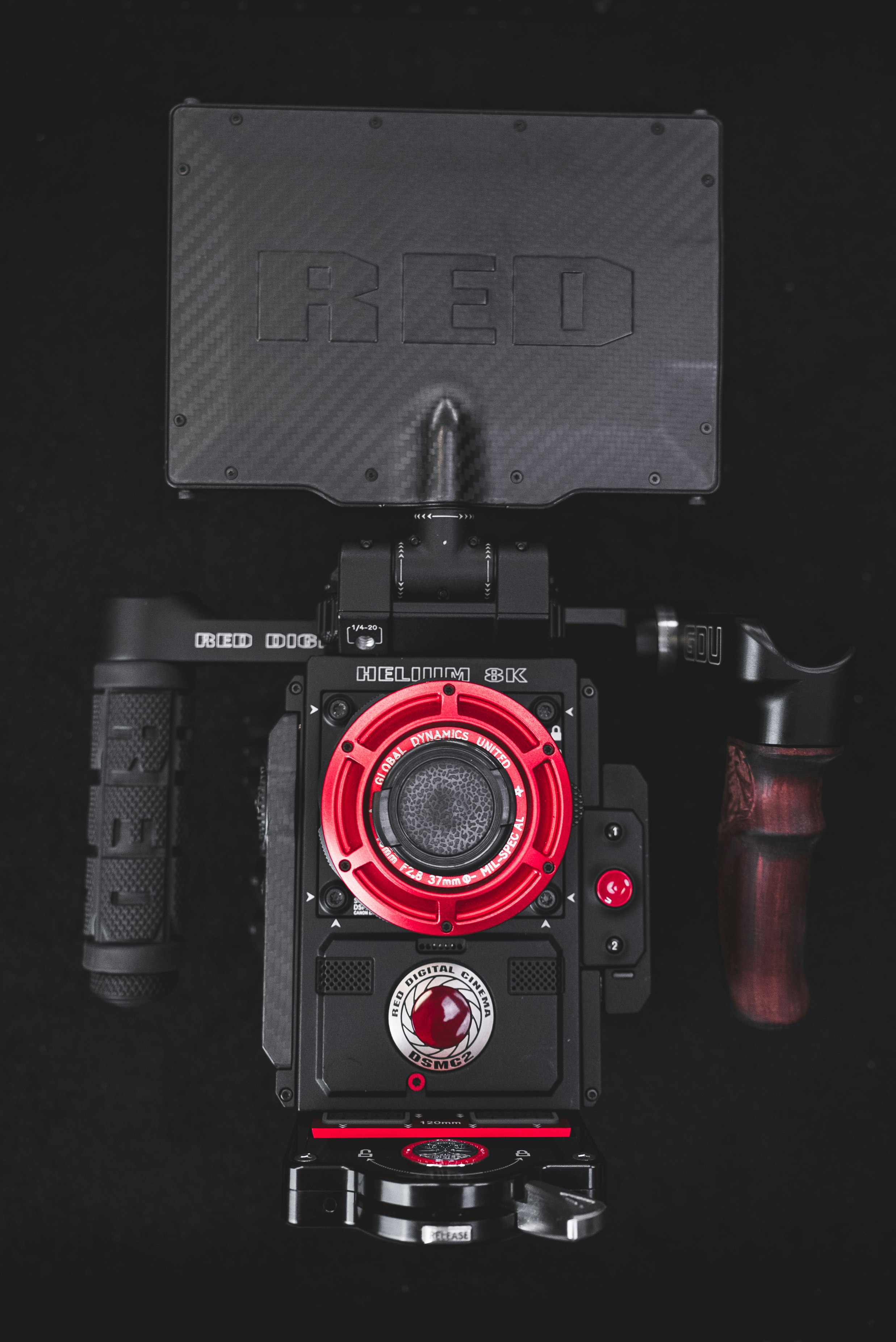 A DSMC2 RED Helium 8K Digital Cinema Camera outfitted with a custom modified 40mm Lens, 120mm Touch n Go Baseplate, and Cowboy Side Handle from high-end manufacturer Global Dynamics United. All of which are now available at our humble San Diego shop.