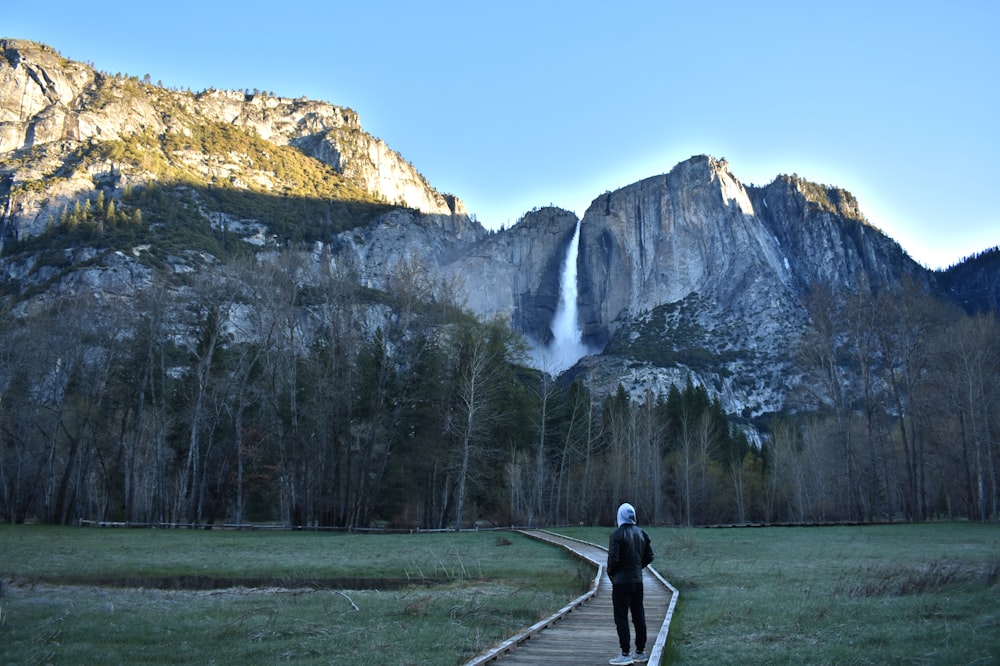 man on pathway towards mountaini