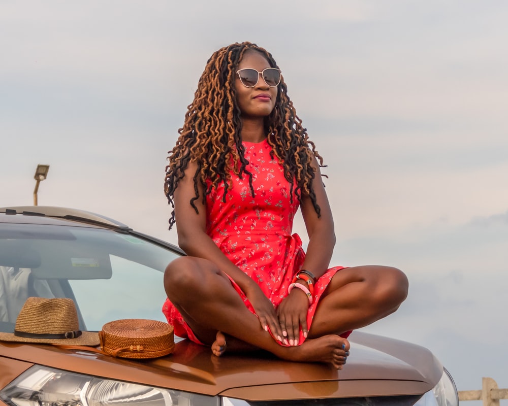 woman sitting on car hood