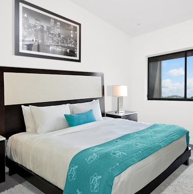 white bedspread and black wooden bed