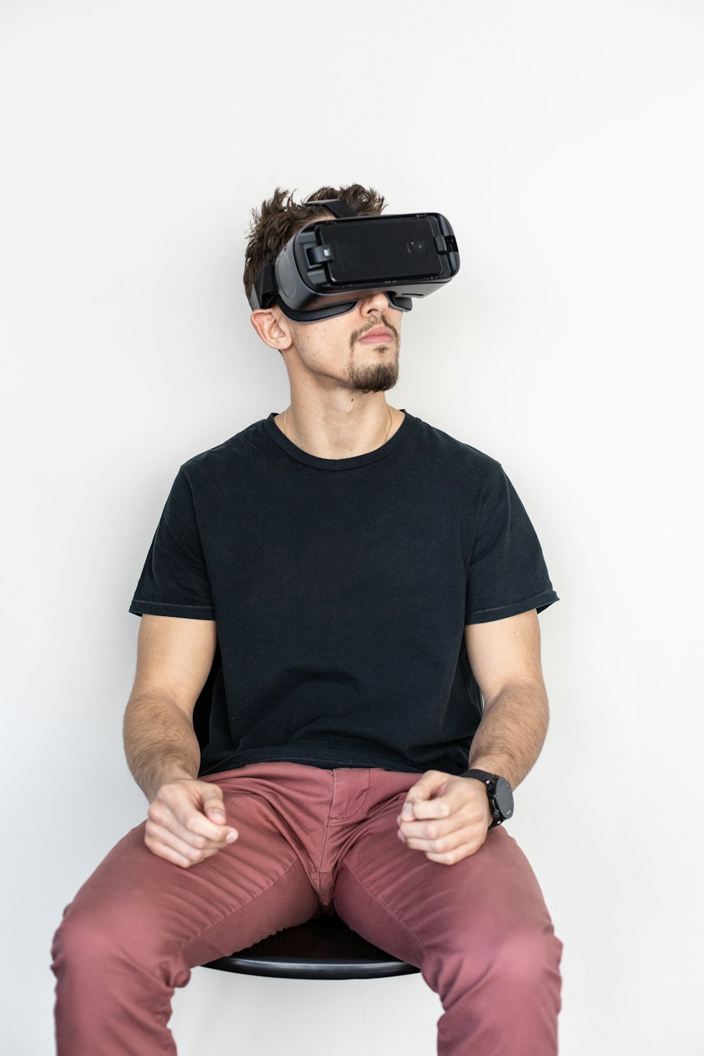 man sitting and using black virtual reality headset