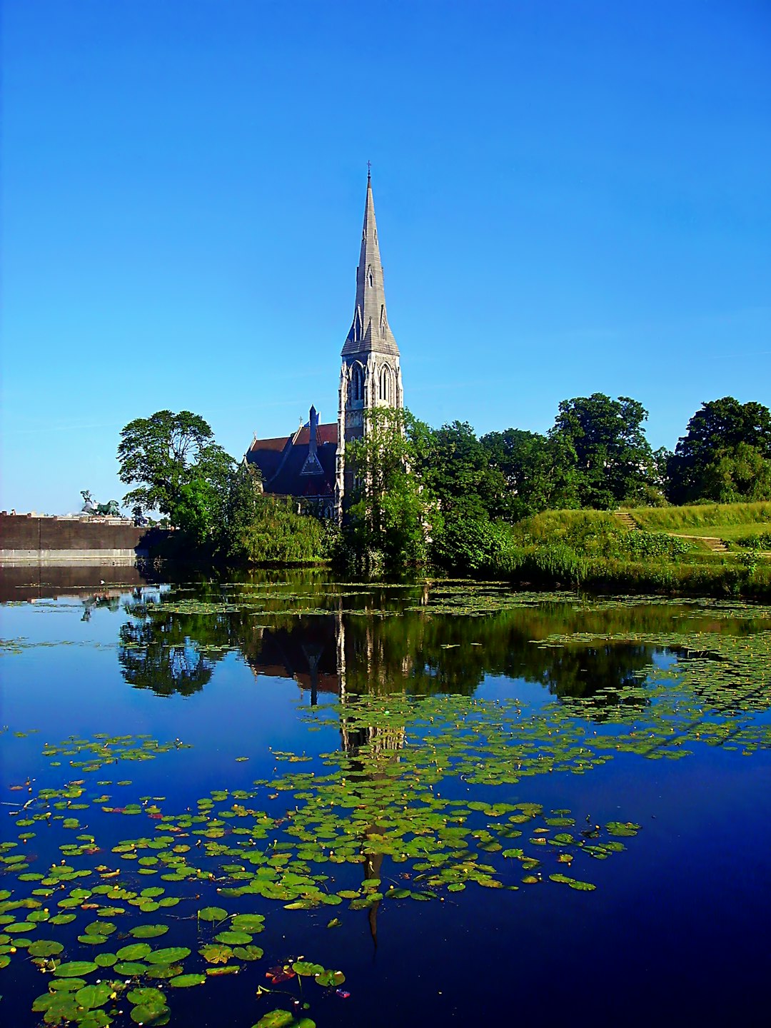 St. Alban's church near body of water under blue and white sky during daytime