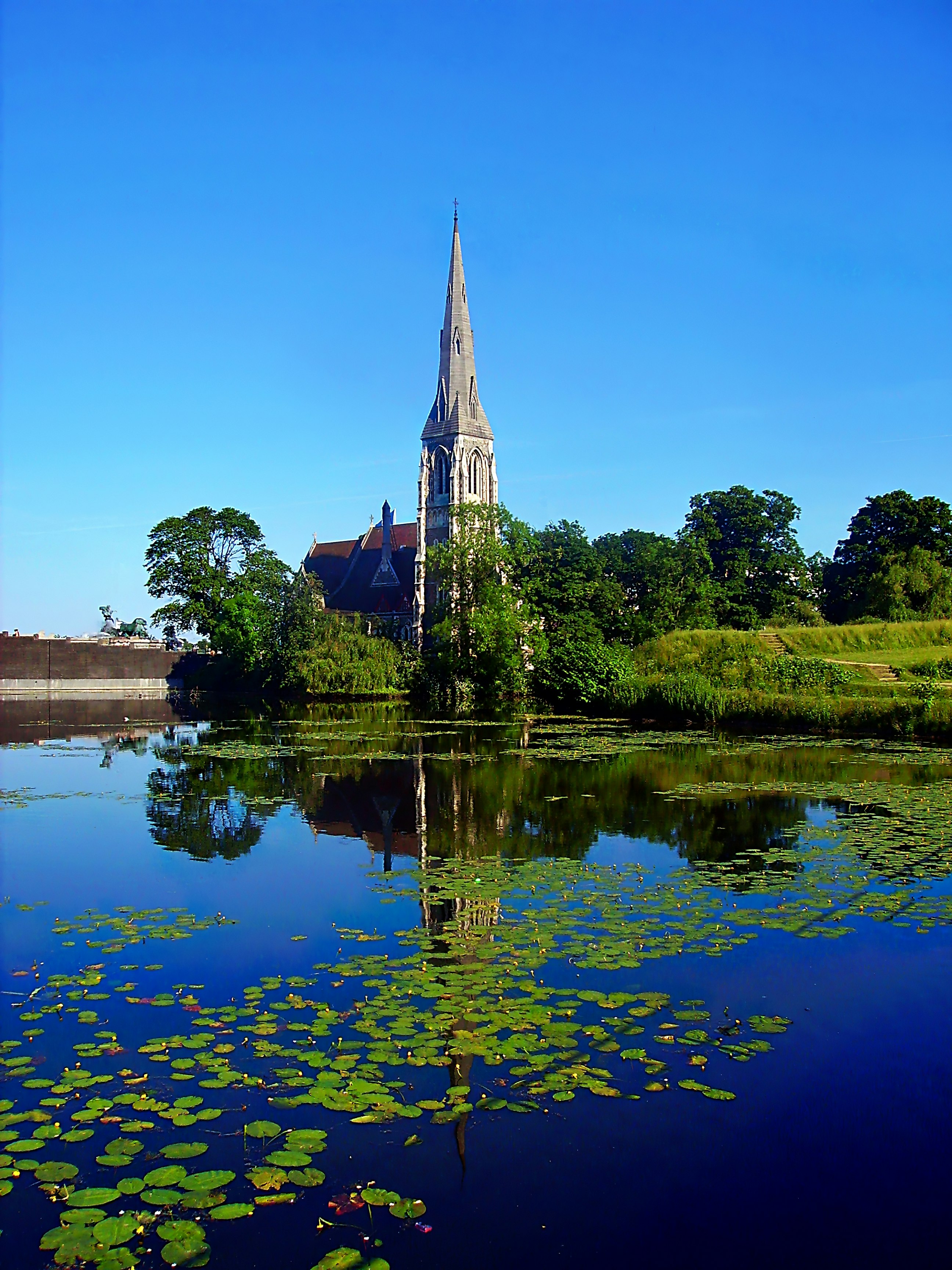 St. Alban's church near body of water under blue and white sky during daytime