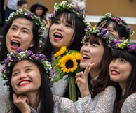 A joyful moment during a flower-crown workshop, with vibrant blossoms and warm smiles all around.