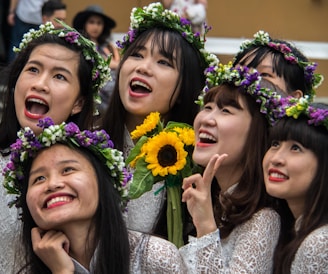 A joyful moment during a flower-crown workshop, with vibrant blossoms and warm smiles all around.