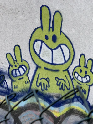 Artist working on a large-scale rabbit mural with vibrant paint strokes.