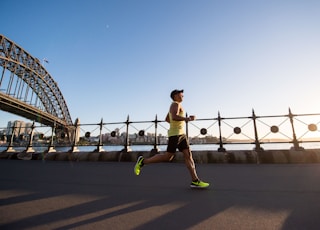 man in yellow tank top running near shore