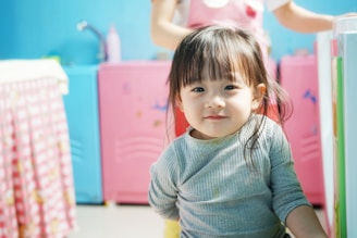 Child with a playful, neat haircut, smiling in the cozy, stylish interior of the salon.
