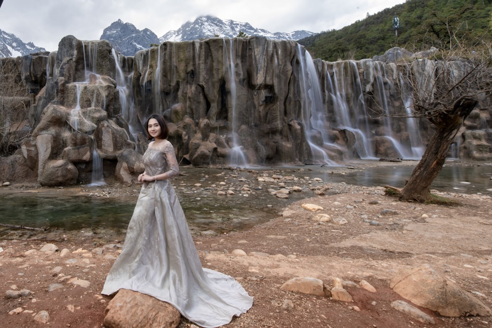 woman standing near near waterfall during daytime