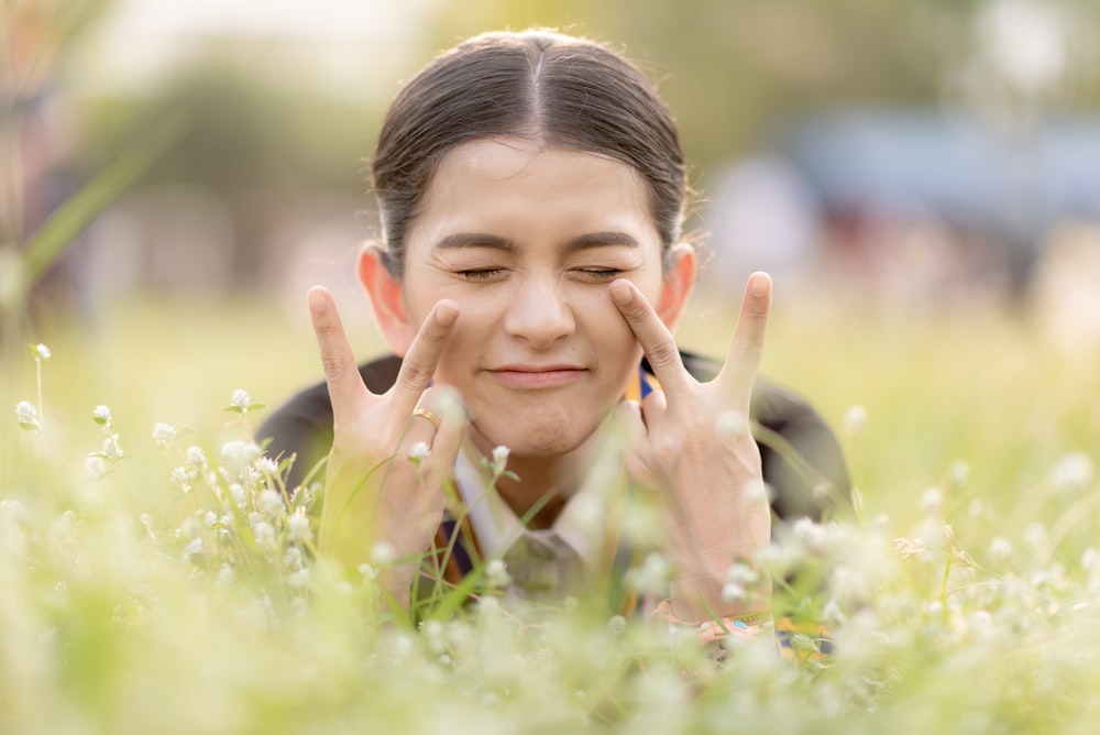 selective focus photography of woman leaning on green grass field during daytime