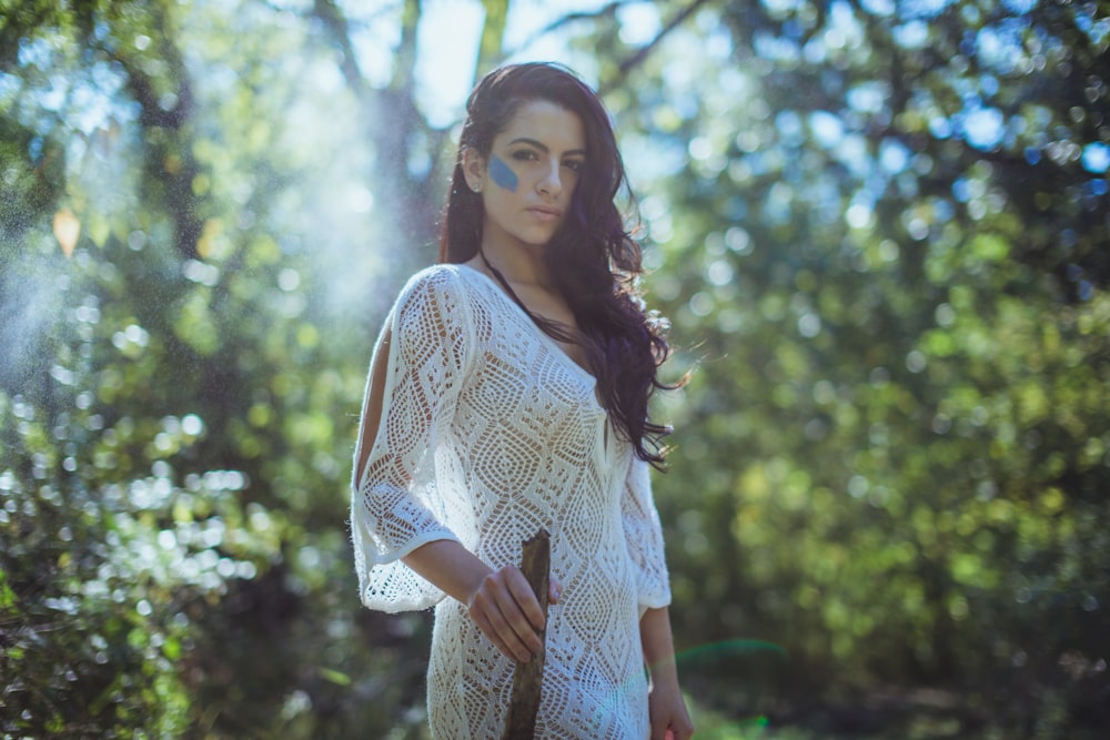 woman in white dress standing under tree