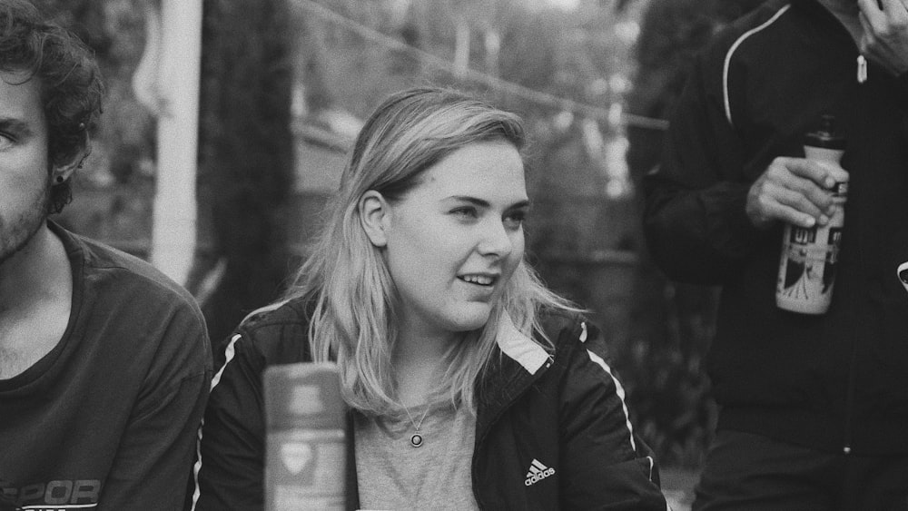 grayscale photo of woman in black adidas jacket