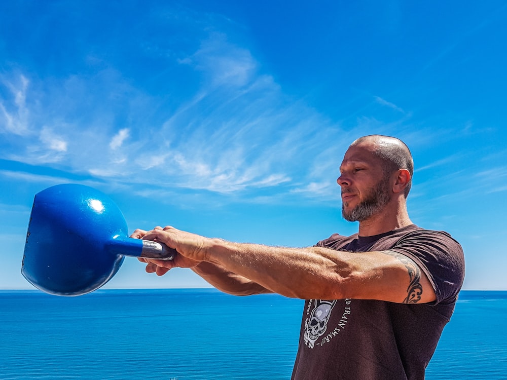 homme portant bouilloire bleue