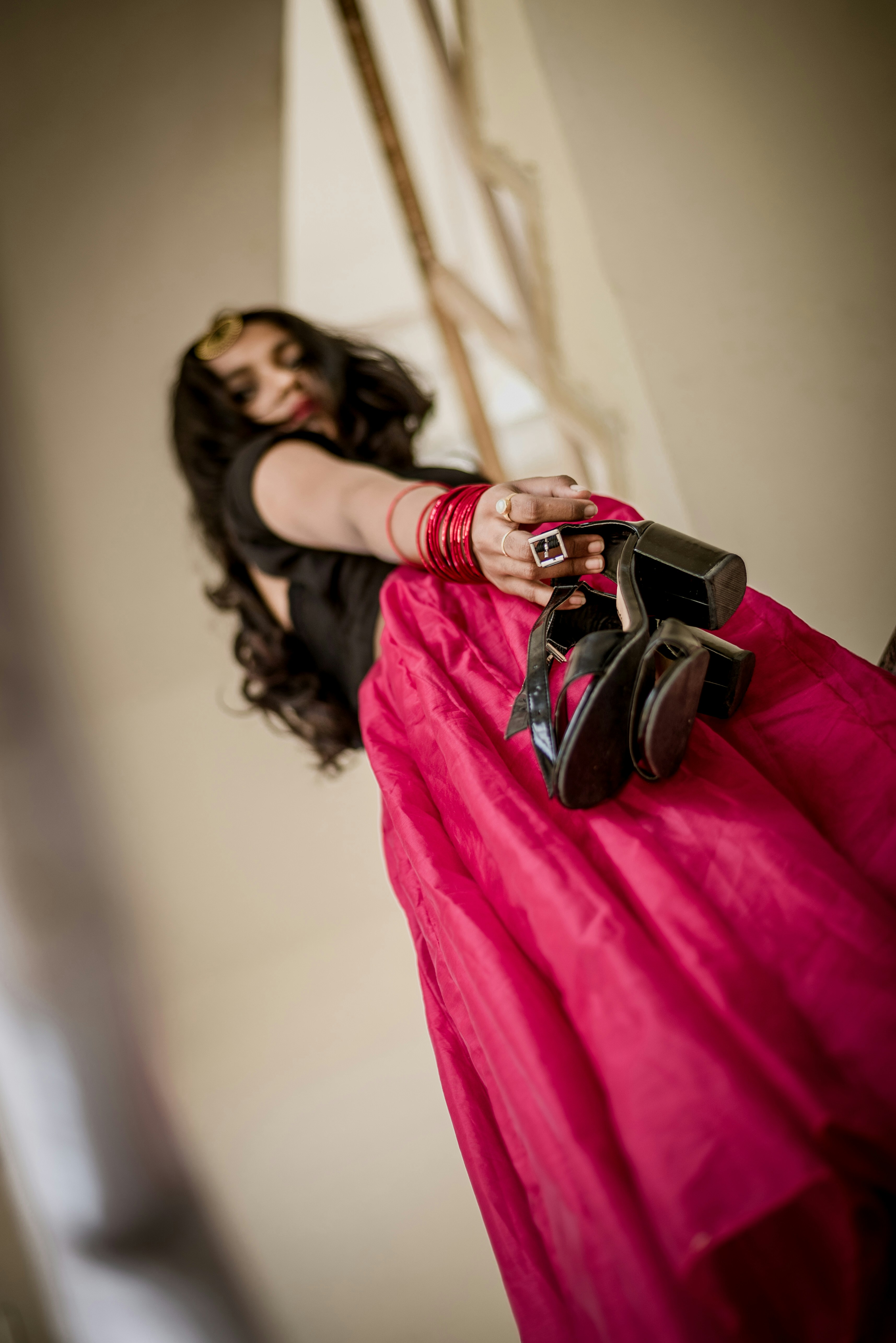 Frau steht, während sie Sandalen hält