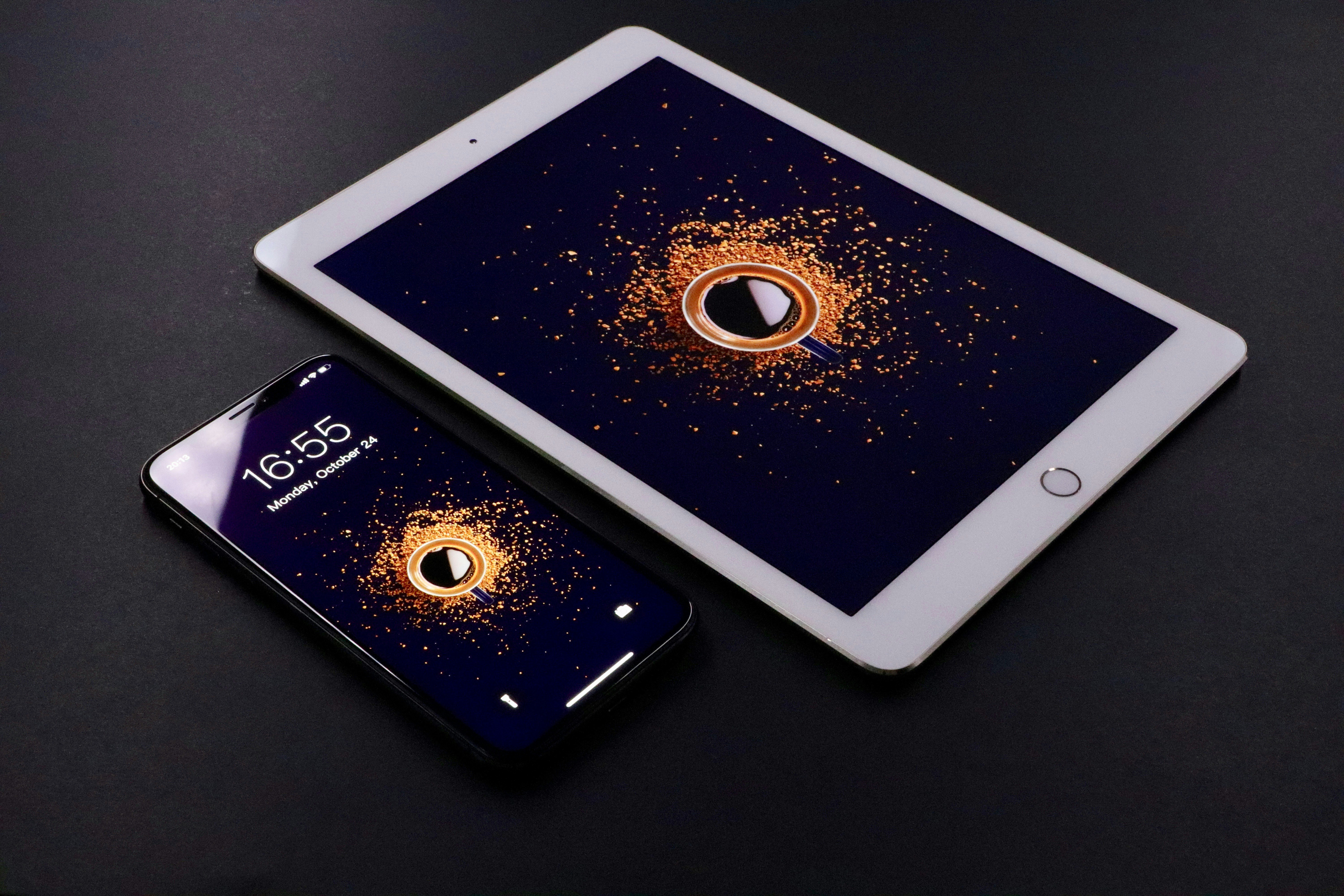 gold Apple iPad and black smartphone