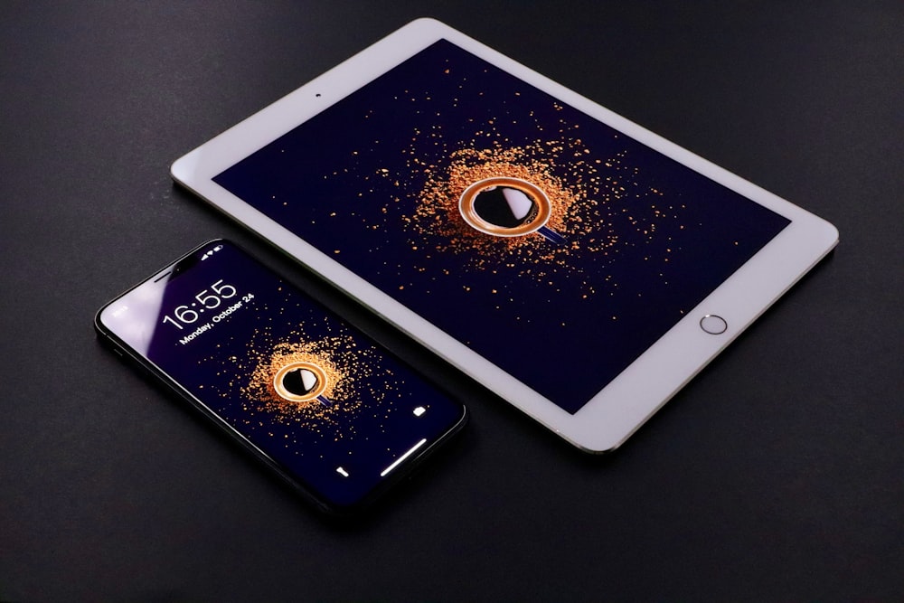 gold Apple iPad and black smartphone