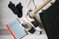 Flat lay of colorful clothing and accessories arranged neatly on a wooden surface.