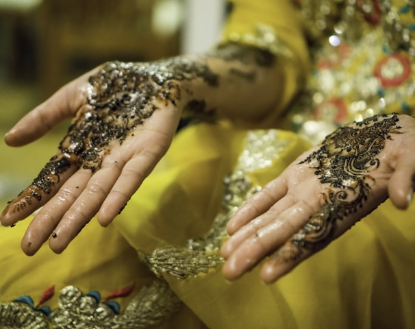 person's hands with mehndi tattoos