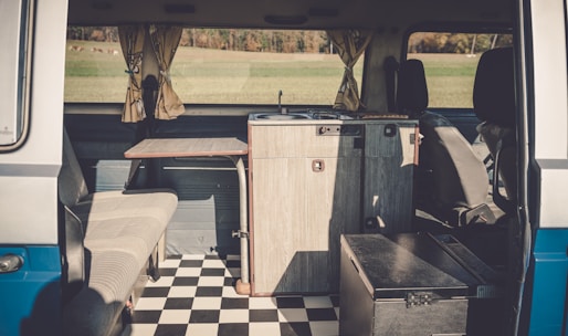 Interior view of a camper van showing a compact kitchen and comfortable seating area.