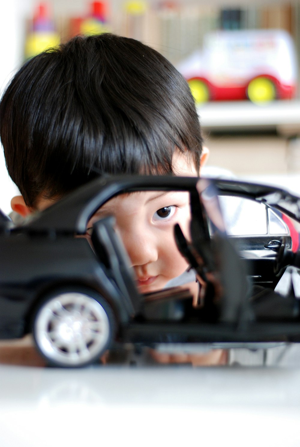 boy playing with car toy